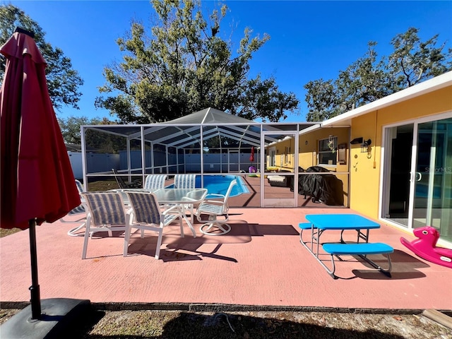 view of patio / terrace featuring a fenced in pool and glass enclosure