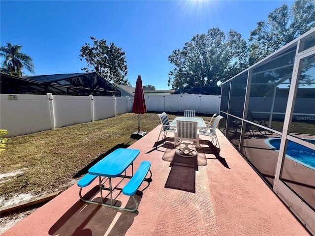 view of patio / terrace with a fenced in pool and glass enclosure