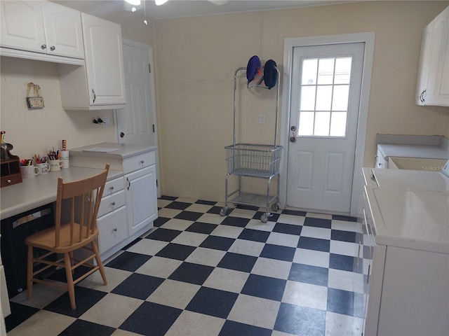 kitchen with washing machine and clothes dryer, a breakfast bar, and white cabinets