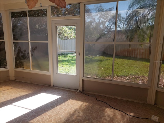 unfurnished sunroom featuring ceiling fan