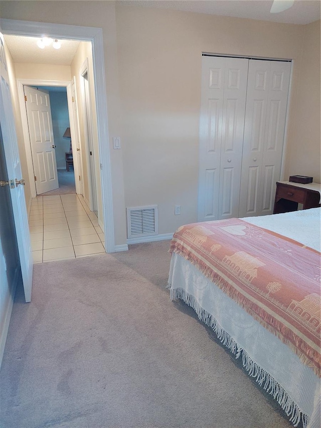 bedroom featuring ceiling fan, light colored carpet, and a closet