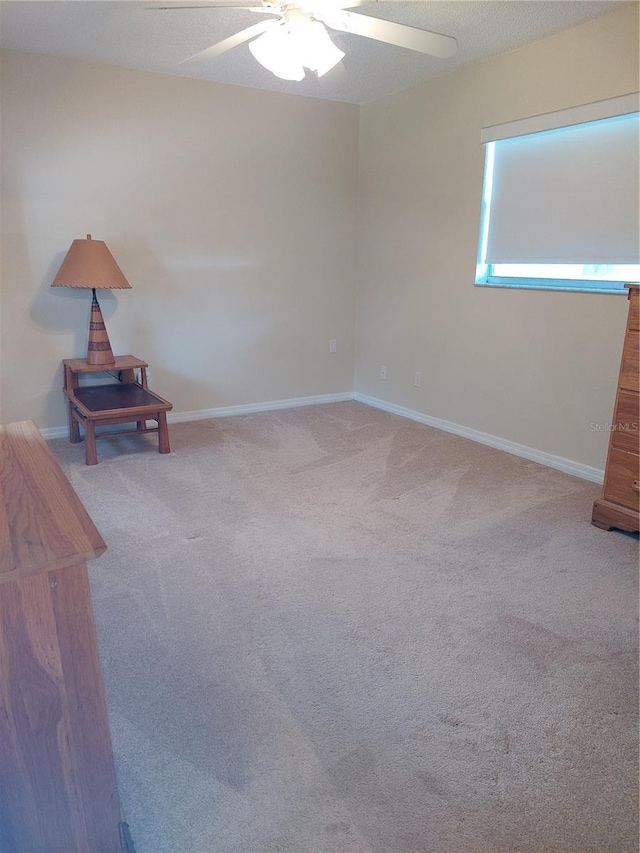 carpeted spare room with ceiling fan and a textured ceiling