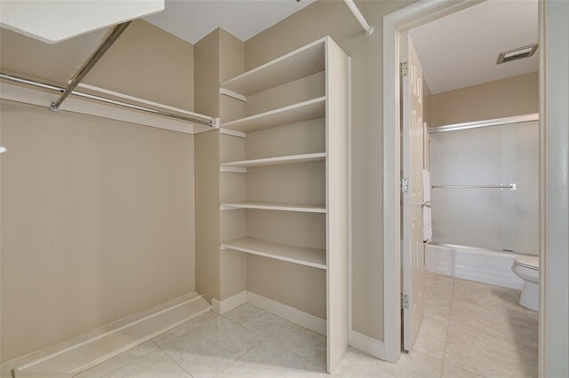 spacious closet with light tile patterned floors