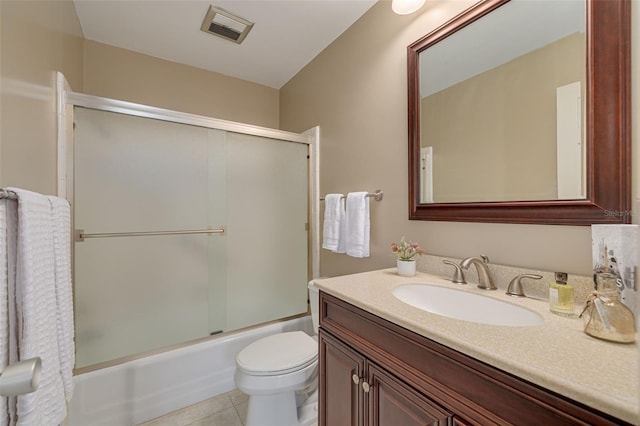 full bathroom with tile patterned flooring, vanity, toilet, and shower / bath combination with glass door