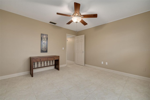 tiled spare room featuring ceiling fan