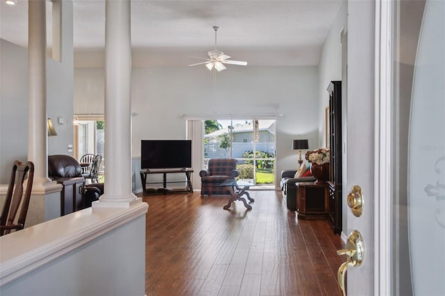 living room featuring dark hardwood / wood-style flooring, ornate columns, and ceiling fan