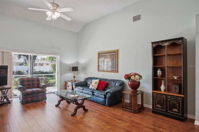 living room with dark hardwood / wood-style flooring, vaulted ceiling, and ceiling fan