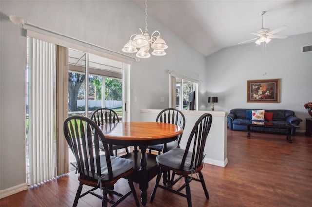 dining area featuring ceiling fan with notable chandelier, dark wood-type flooring, and vaulted ceiling