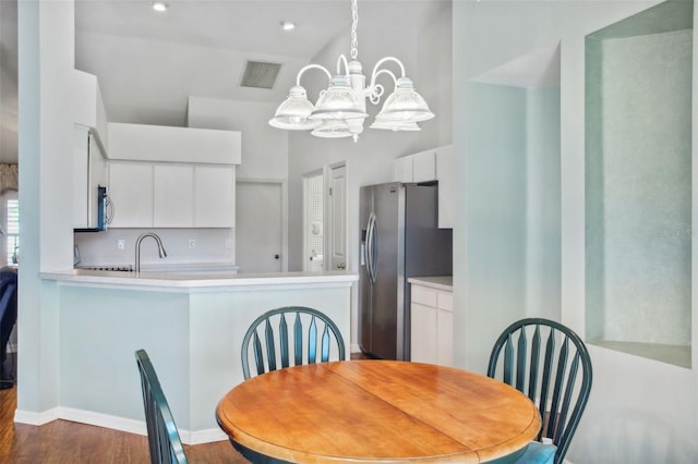 dining area with a chandelier, dark hardwood / wood-style floors, and sink