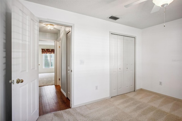 unfurnished bedroom featuring ceiling fan, a closet, and wood-type flooring