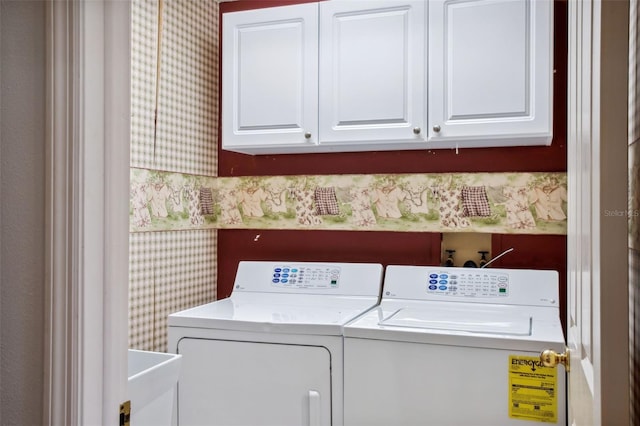 laundry room featuring washer and clothes dryer and cabinets