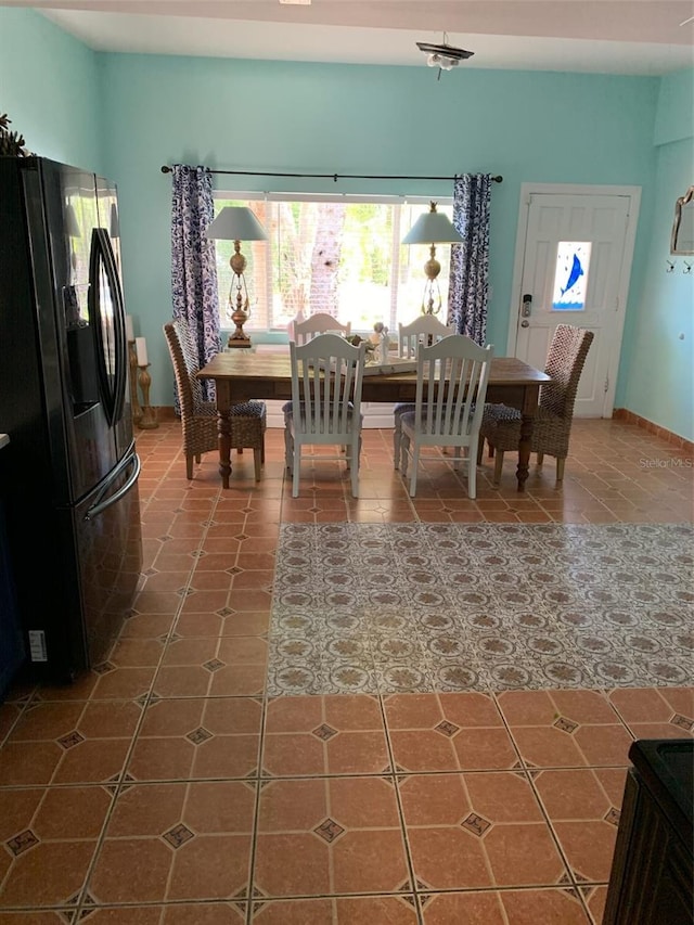 tiled dining space featuring a healthy amount of sunlight