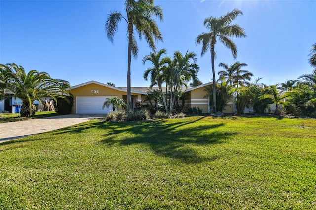 ranch-style house featuring a front yard and a garage