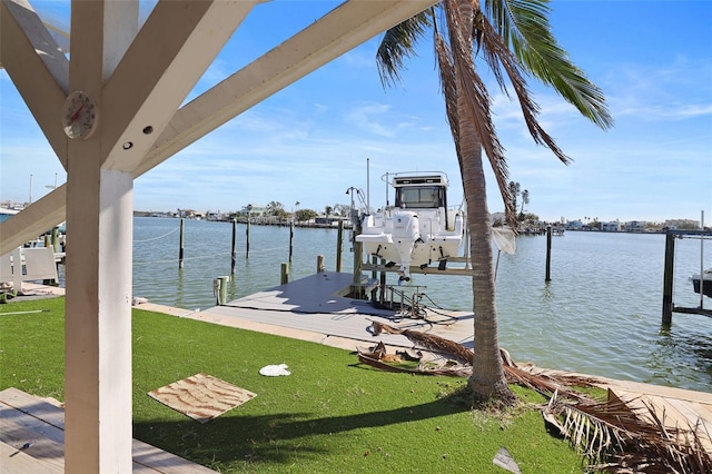 dock area with a lawn and a water view