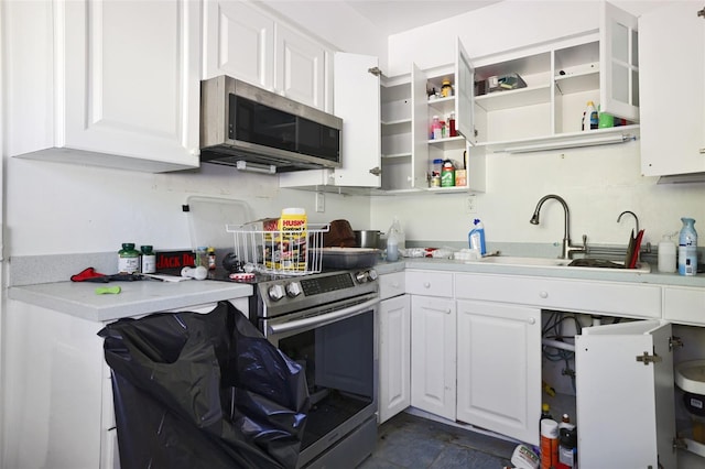 353 144th Ave, Madeira Beach, FL 33708 - kitchen featuring appliances with stainless steel finishes, a sink, white cabinets, and light countertops