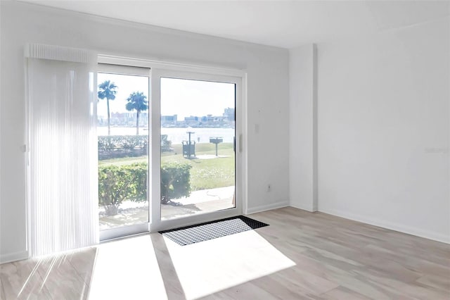 doorway to outside with light wood-type flooring, baseboards, and a view of city