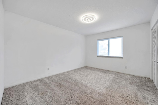 empty room featuring carpet and a textured ceiling