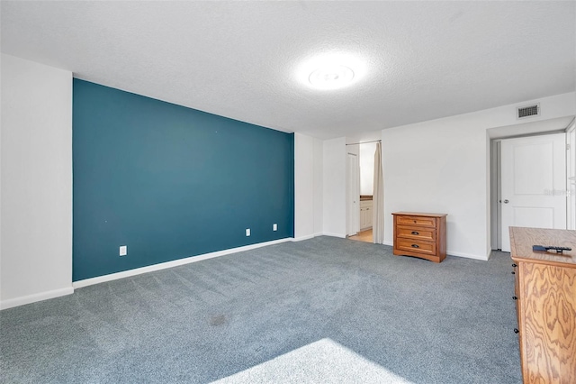 unfurnished bedroom with dark colored carpet, baseboards, visible vents, and a textured ceiling