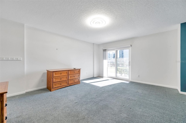 unfurnished room featuring baseboards, carpet flooring, and a textured ceiling