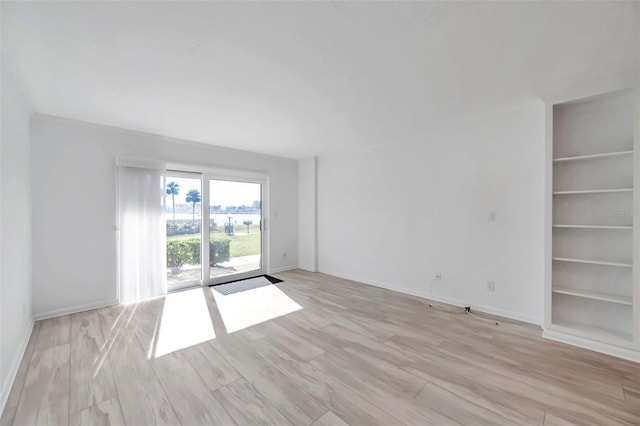 650 Island Way Unit 106, Clearwater Beach, FL 33767 - spare room with built in shelves, light wood finished floors, and baseboards