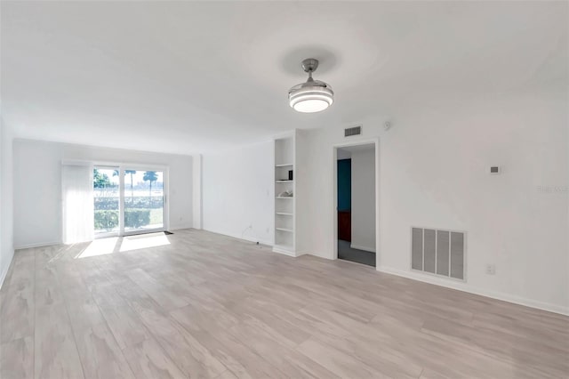 650 Island Way Unit 106, Clearwater Beach, FL 33767 - unfurnished living room featuring baseboards, visible vents, and light wood-style flooring