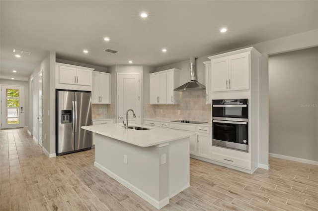 kitchen with white cabinetry, sink, wall chimney exhaust hood, and appliances with stainless steel finishes