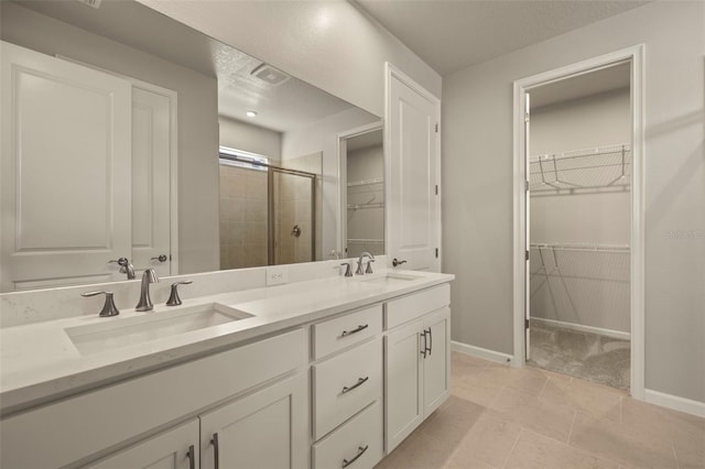 bathroom featuring vanity, tile patterned flooring, and walk in shower