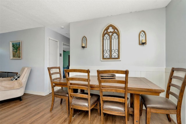 dining area featuring light hardwood / wood-style flooring and a textured ceiling