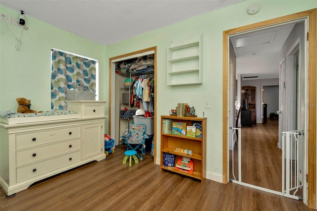 bedroom with wood-type flooring, a textured ceiling, and a closet