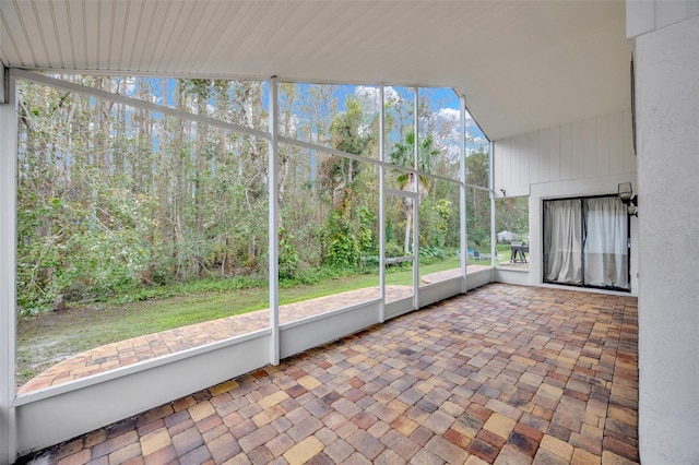 unfurnished sunroom featuring lofted ceiling