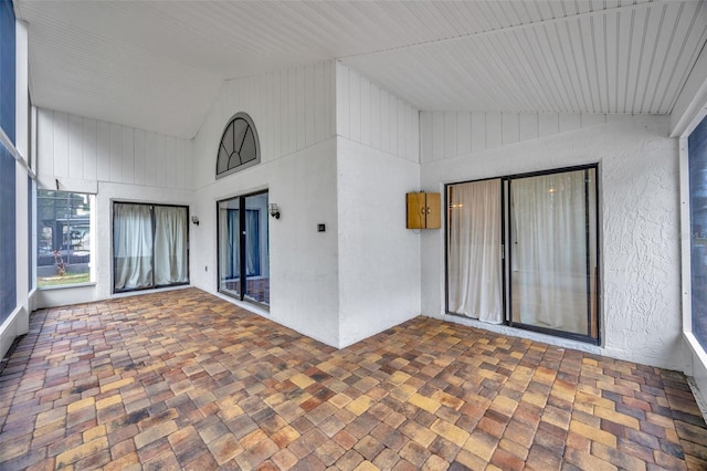 unfurnished sunroom with lofted ceiling