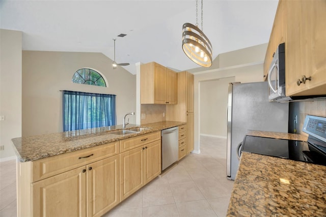 kitchen with light brown cabinets, sink, light stone countertops, kitchen peninsula, and stainless steel appliances