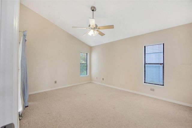 carpeted empty room featuring vaulted ceiling, plenty of natural light, and ceiling fan