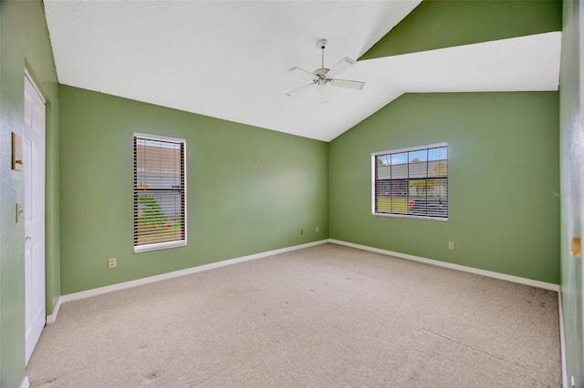 carpeted spare room featuring vaulted ceiling and ceiling fan