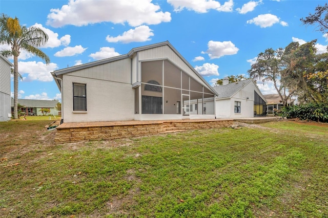 back of property featuring a yard and a sunroom