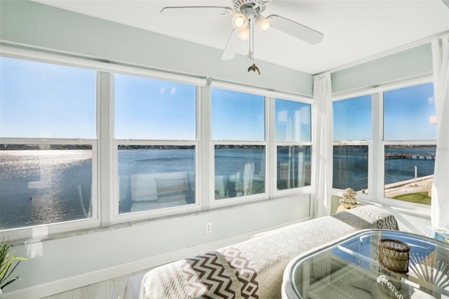 bedroom with a water view and a ceiling fan