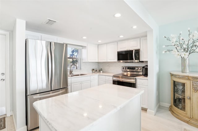 kitchen featuring a center island, white cabinetry, sink, and appliances with stainless steel finishes