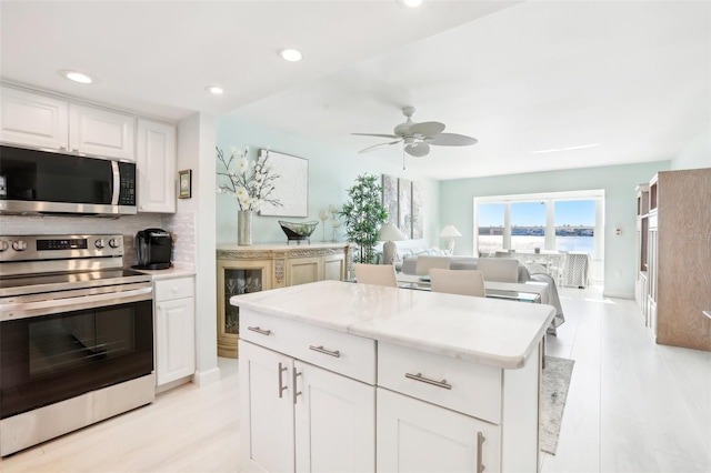 kitchen with appliances with stainless steel finishes, recessed lighting, white cabinetry, and tasteful backsplash