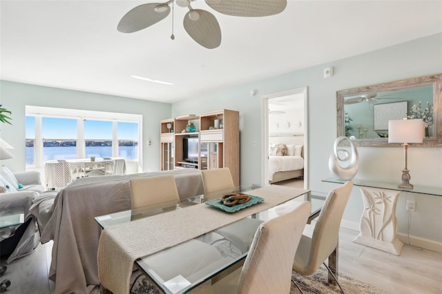 dining space with light wood-type flooring, ceiling fan, and baseboards