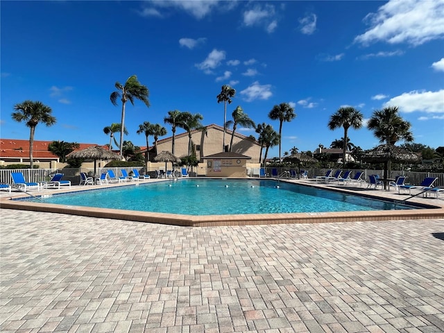 community pool with a patio area and fence