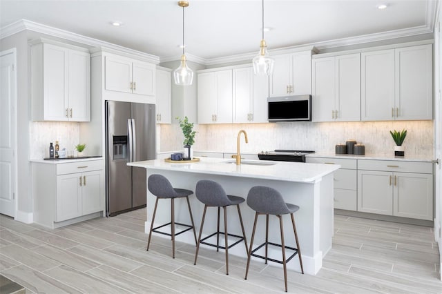 kitchen with white cabinetry, sink, hanging light fixtures, a center island with sink, and appliances with stainless steel finishes