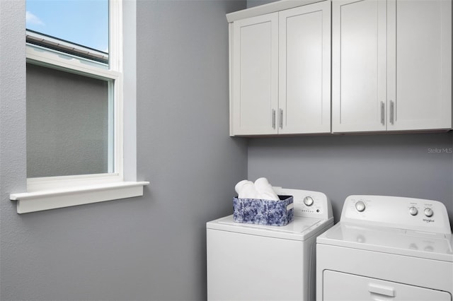 washroom with cabinets and washer and clothes dryer