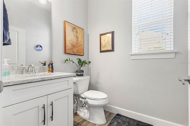 bathroom featuring wood-type flooring, vanity, and toilet