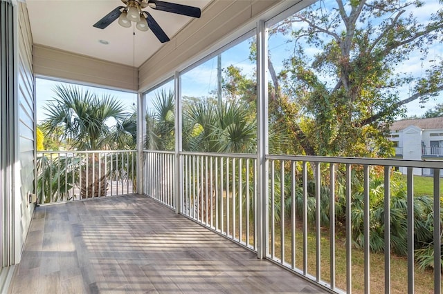 unfurnished sunroom with ceiling fan