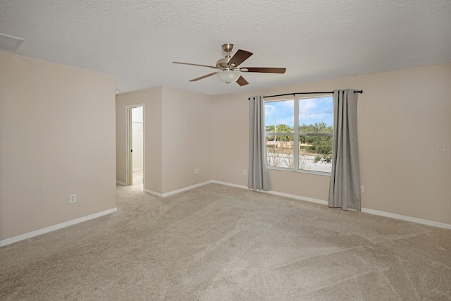 empty room with ceiling fan, light colored carpet, and a textured ceiling