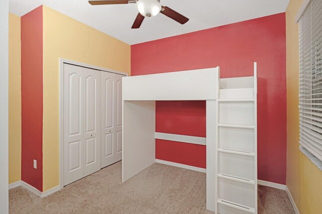 unfurnished bedroom featuring ceiling fan, a closet, and carpet floors