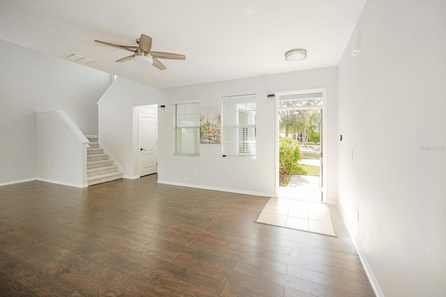 unfurnished living room featuring ceiling fan and dark wood-type flooring