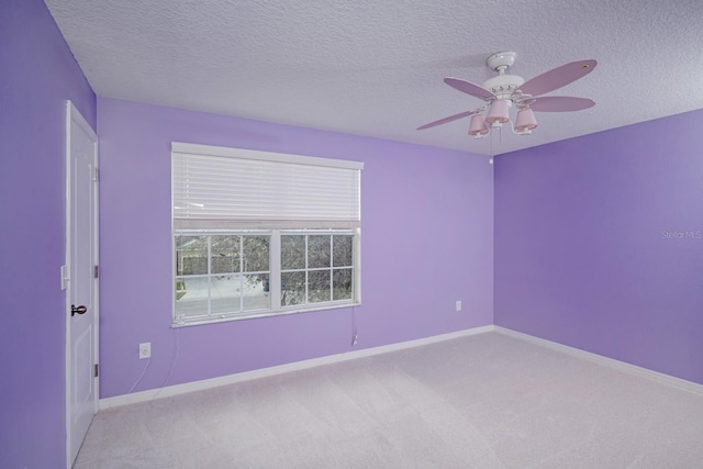 carpeted empty room with ceiling fan and a textured ceiling