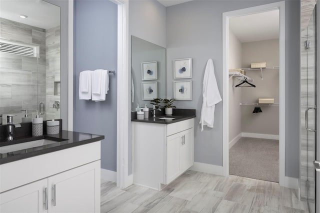 bathroom with vanity and a shower with door