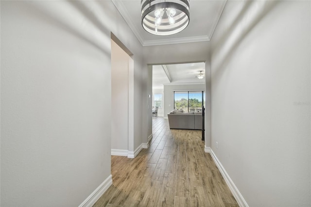 corridor featuring ornamental molding, light hardwood / wood-style flooring, a notable chandelier, and beam ceiling